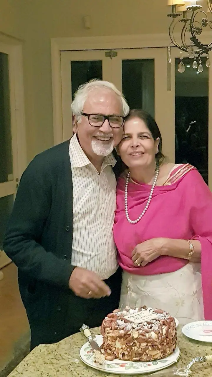 Mama and Bapuji smiling beside a cake